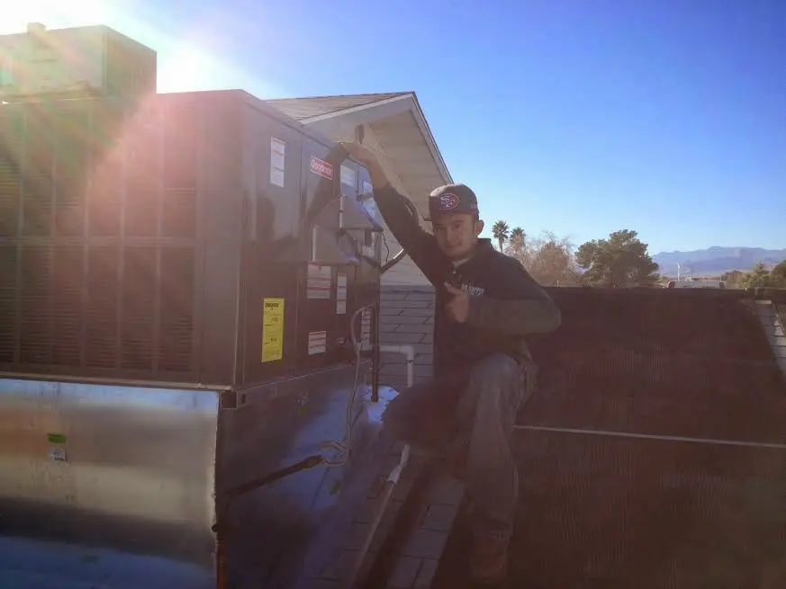 HVAC technician performing Heat Pump Repair on a rooftop unit in Lake Station